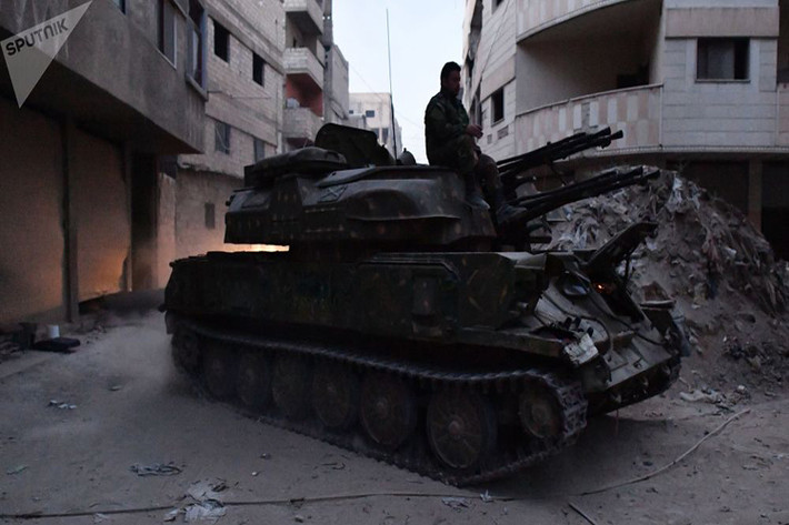 Với đà tấn công của Quân đội Syria tại Yarmouk hiện tại chẳng mấy chốc họ sẽ san phẳng khu vực này bằng sức mạnh hỏa lực, khi các ổ đề kháng của IS tại đây lần lượt bị xóa sổ bằng pháo binh lẫn không quân. Và cơ hội để các tay súng IS và gia đình thoát ra khỏi Yarmouk là gần như bằng không. Ảnh: Sputnik.