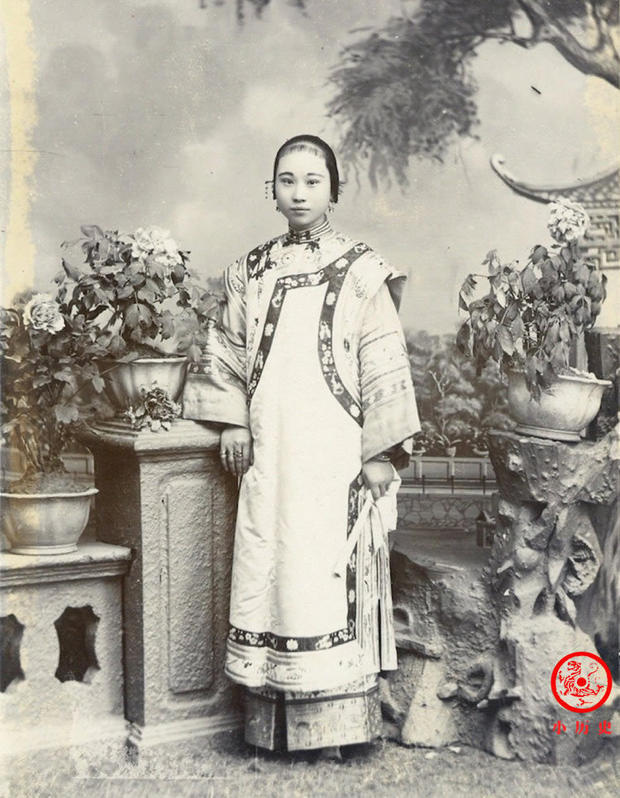 Hình ảnh của một cô gái xuất thân quyền quý. Mặc dù được chụp trong phòng chụp ảnh nhưng bối cảnh lại sắp xếp phức tạp, tạo cảm giác như một khu vườn thật. Những họa tiết thêu trên trang phục của cô rất tinh tế, thể hiện khả năng tài chính gia đình rất tốt.