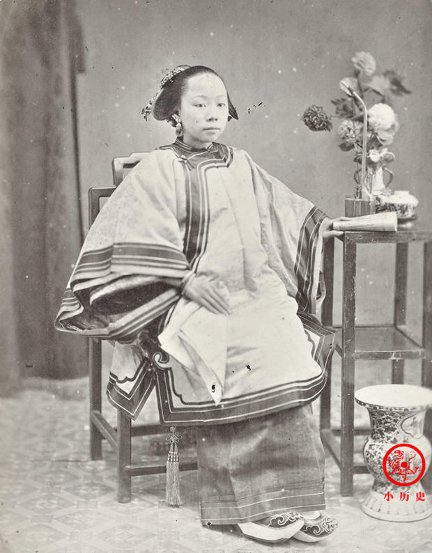 Một phụ nữ người Khách Gia (hay còn gọi là người Hẹ). Tay trái của cô đang cầm một quyển sách, đây là tư thế quen thuộc khi chụp ảnh trong phòng chụp ảnh cuối thời nhà Thanh.