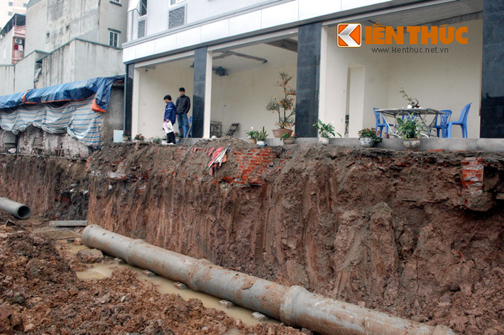 Các ngôi nhà bên công trường thi công cống thoát nước đường Nguyễn Văn Huyên kéo dài như nằm chênh vênh trên vực thẳm.