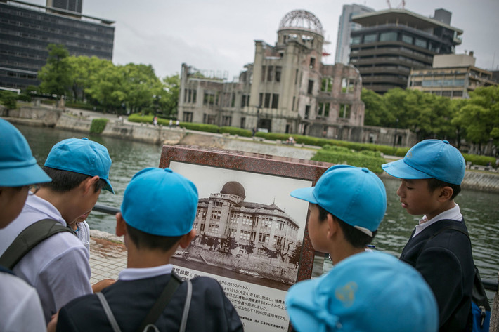 Các em nhỏ đang nhìn một bức ảnh cũ chụp Mái vòm nguyên tử tưởng niệm thảm họa Hiroshima. Ảnh chụp ngày 26/5/2016, một ngày trước khi Tổng thống Mỹ Barack Obama tới thăm thành phố Hiroshima.