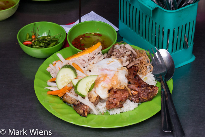 Cơm tấm: Đến Sài Gòn, du khách không thể bỏ lỡ món ăn vỉa hè hấp dẫn có tên cơm tấm. Cơm được nấu từ tấm gạo, dọn ăn cùng sườn nướng, trứng ốp, chả, bì và rưới nước sốt. Ảnh: Migrationology.