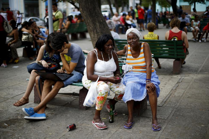 Đông người dân ngồi gần một điểm phát wifi ở quảng trường ở La Habana.