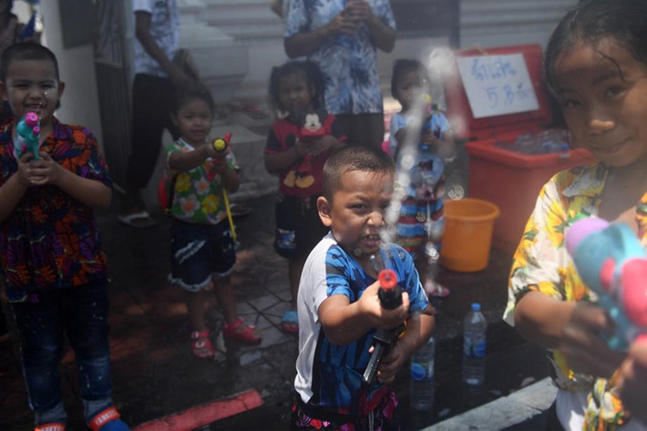 Trẻ em chơi đùa với súng phun nước khi ăn mừng Songkran trên đường Khaosan ở Bangkok. Các nước láng giềng như Lào và Myanmar ăn mừng cùng một lễ hội với người dân cả già lẫn trẻ hắt nước vào nhau khi tiếng nhạc phát ra từ loa phóng thanh.