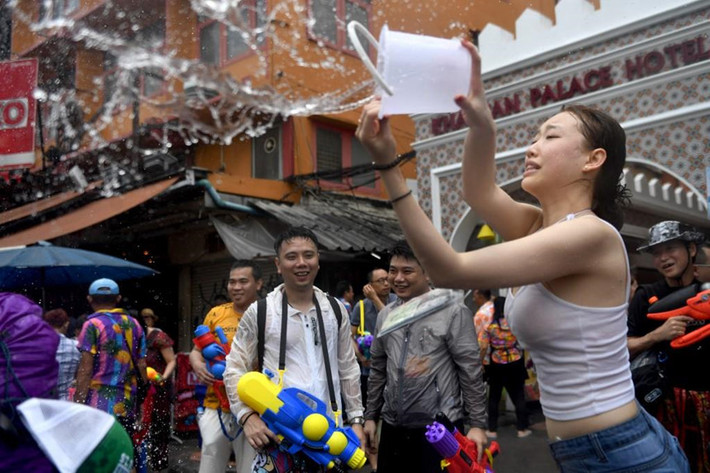 Một du khách Trung Quốc trong lễ hội Songkran trên đường Khaosan ở Bangkok. Lễ hội năm mới - được gọi là Songkran ở Thái Lan, Chol Chnam Thmay ở Campuchia, Bunpimay ở Lào và Thingyan ở Myanmar - diễn ra vào tháng 4 hàng năm. Truyền thống té nước là để rửa sạch xui xẻo và cầu nguyện cho một năm mới tốt lành.