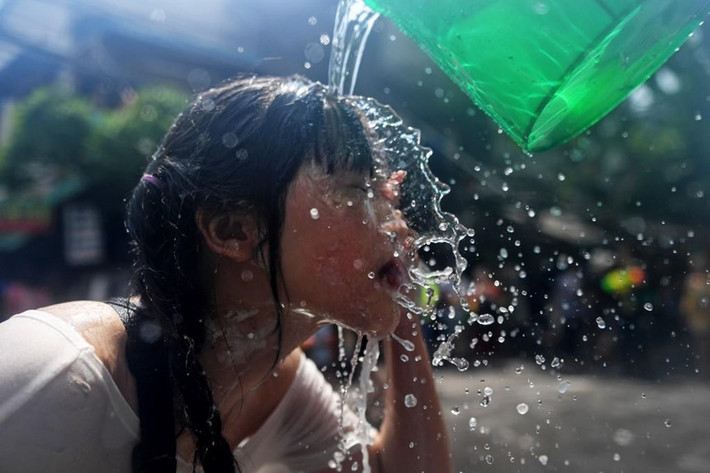 Một phụ nữ rửa mặt bằng nước trên đường Khaosan ở Bangkok, ngày 13/4. Songkran cũng là thời gian nguy hiểm nhất để đi du lịch ở Thái Lan. Tuần bắt đầu từ ngày 11/4 được mệnh danh là "bảy ngày nguy hiểm" khi hàng triệu người Thái thực hiện hành trình về quê bằng xe buýt, xe tải hoặc xe máy.
