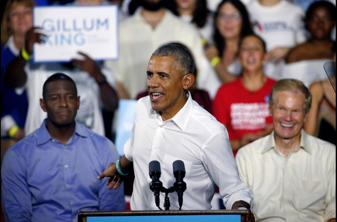 Ngoài diễn thuyết và bán sách, nhà Obama còn tham gia quảng cáo và sở hữu bất động sản đồ sộ. Gia đình Obama sống trong biệt thự rộng 760 m2 với 9 phòng ngủ, lần cuối được rao bán với giá 5,3 triệu USD. Căn biệt thự nằm trong khu Kalorama sầm uất, nơi ái nữ của tổng thống đương nhiệm - Ivanka Trump cũng sở hữu một căn nhà. Trong ảnh, ứng cử viên Thống đốc bang Florida, Andrew Gillum, (trái) và Thượng nghị sĩ Bill Nelson (phải) lắng nghe ông Obama khi ông đang diễn thuyết bỏ phiếu cho một cuộc mít tinh tại Miami. Ảnh: Getty Images.