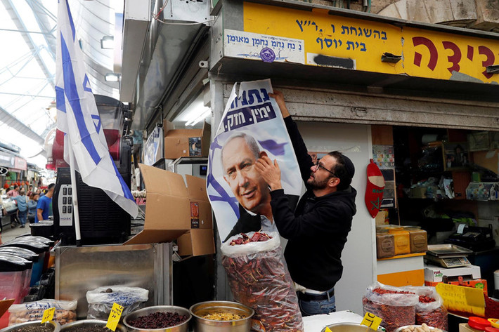 Một người dân treo khẩu hiệu của đảng Likud ở khu chợ Mahane Yehuda tại Jerusalem, nếu thắng cử, ông Netanyahu sẽ bước vào nhiệm kỳ thủ tướng thứ 5, nhiều hơn nhà lập quốc David Ben-Gurion với 4 nhiệm kỳ. Ảnh: Reuters.