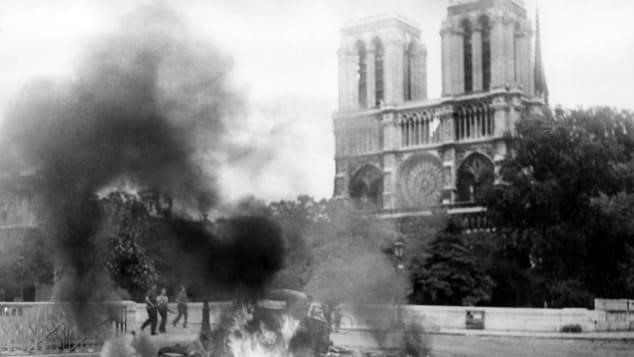 Nhà thờ Đức Bà cũng sống sót qua Thế chiến II, dù Paris đã bị chiếm đóng, cờ phát-xít Đức đã bay trên các tòa nhà chính phủ Pháp, và đồng hồ ở đây bị đổi theo giờ Berlin. "Vào những ngày giải phóng Paris năm 1944, có giao tranh ác liệt trên đường phố Paris khi lính Đức cố bám giữ", giáo sư sử học Peter McPhee từ Đại học Melbourne nói với trang ABC. "Vì vậy Nhà thờ Đức Bà đã có chút hư hại". Ảnh được chụp tháng 8/1944, ngay trước khi Paris được giải phóng. Ảnh: Getty Images.