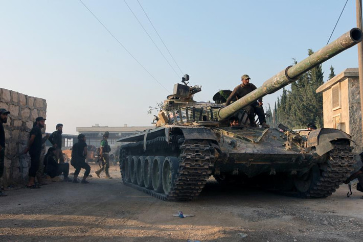 Các chiến binh nổi dậy lái xe tăng tiến vào một ngôi trường pháo binh ở Aleppo.