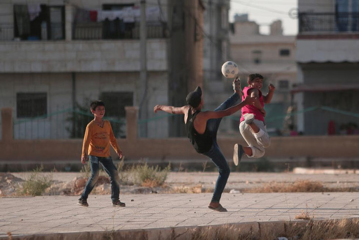 Các bé trai chơi bóng đá trên đường phố ở thị trấn Syria mới giải phóng.