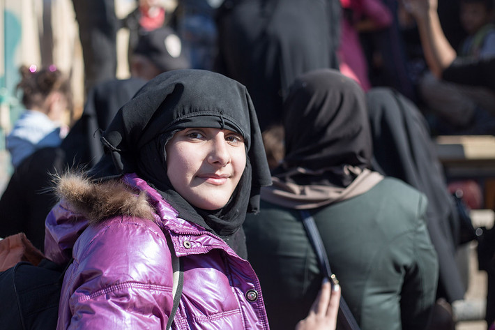 Thiếu nữ tới từ một khu vực của Mosul mới bị phiến quân IS giành lại được kéo mạng che mặt xuống trong lúc chờ lên xe. Ảnh AJ
