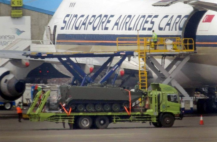 Phương tiện vận chuyển 5 chiếc thiết giáp này là một máy bay vận tải của hãng hàng không Singapore. Ảnh: Xe thiết giáp M113 phiên bản lưỡng cư được di chuyển trên đường băng. Nguồn ảnh: Defence.