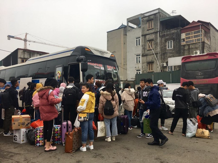 Nhiều người tập trung tại một xe khách đang chuẩn bị xuất bến.