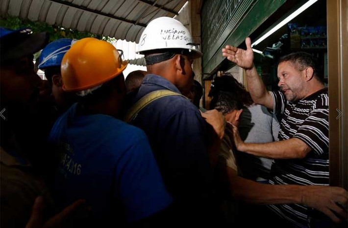 Cảnh xô đẩy bên ngoài một cửa hàng bán bánh mì. Ảnh Reuters