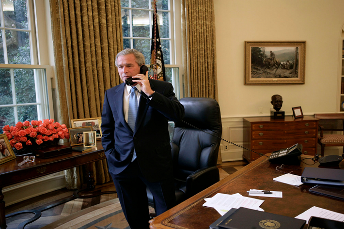 Cựu Tổng thống George W. Bush trông có vẻ bề bộn hơn với một núi giấy tờ, tuy nhiên ông Bush vẫn có những bức ảnh gia đình ở chiếc bàn nhỏ phía sau lưng mình thậm chí là được trang trí hoa đi kèm. Ảnh: Business Insider.