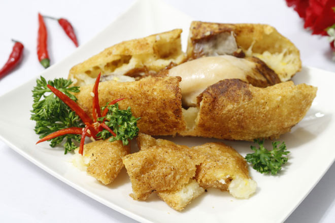 Khi ăn bạn dùng kéo cắt phần vỏ xôi ra thành các miếng vừa ăn, chấm tương ớt ăn kèm với xà lách, rau mùi, dưa leo và thưởng thức khi còn nóng sẽ ngon hơn.