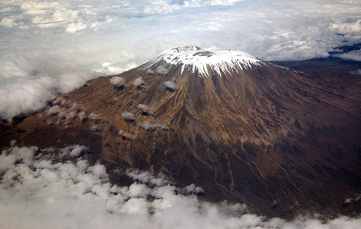 1. Núi Kilimanjaro Núi Kilimanjaro là một ngọn núi lửa hiện tại đã không còn hoạt động. Nó nằm ở phía đông bắc Tanzania, gần biên giới với Kenya. Với độ cao 5.892 m so với mực nước biển, Kilimanjaro là đỉnh cao nhất của châu Phi và là ngọn núi cao nhất thế giới. Tuy nhiên, việc leo lên ngọn núi này lại tương đối dễ dàng. Kilimanjaro đã trở thành điểm đến chính cho những người leo núi và những người đi bộ từ khắp nơi trên thế giới. Mặc dù nằm gần xích đạo, núi Kilimanjaro nổi tiếng là ngọn núi tuyết phủ của Châu Phi.