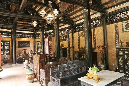 Phòng khách cũng là phòng thờ được gia chủ bày biện nhiều đồ gỗ. Diễn viên cho sắp đặt ba bộ bàn ghế để khách đến có thể thoải mái chọn chỗ ngồi.