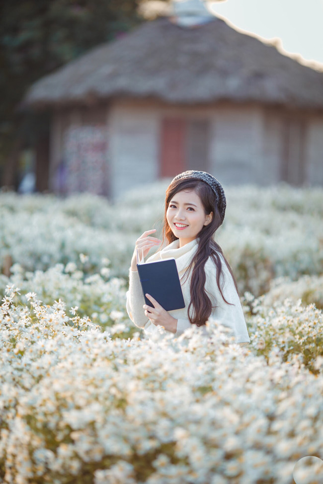 Vẻ đẹp dịu dàng của cô giáo trẻ hòa với sắc trắng tinh khôi của loài hoa mùa đông. Nữ giáo viên chẳng cần tạo dáng cầu kỳ vẫn có được những shoot hình cuốn hút thế này.