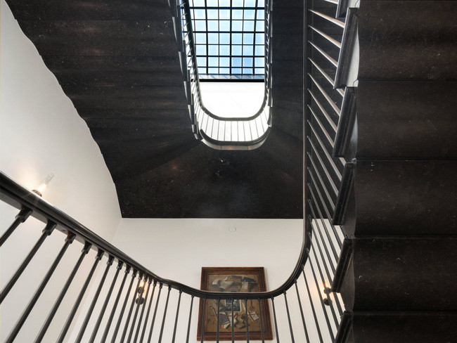 Cầu thang bằng đá cẩm thạch đen dẫn lên tầng trên với phòng ngủ chính của căn penthouse.