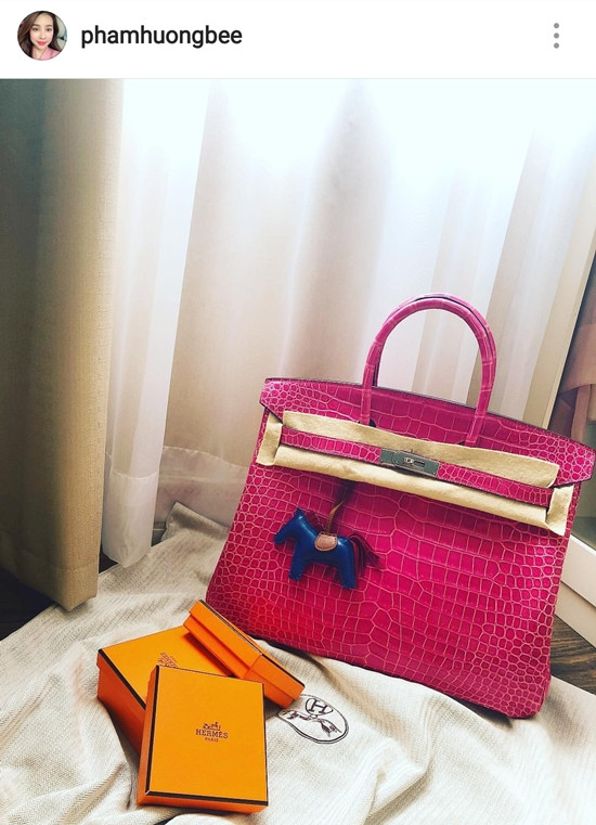 Phạm Hương háo hức đón chiếc túi Hermes Birkin 35 chất liệu da cá sấu màu hồng sen có giá khoảng 1,4 tỷ đồng về tay sau bao ngày đợi mong. Item đã giúp Hoa hậu Phạm Hương soán ngôi vô địch trong cuộc đua túi hiệu tháng 7.