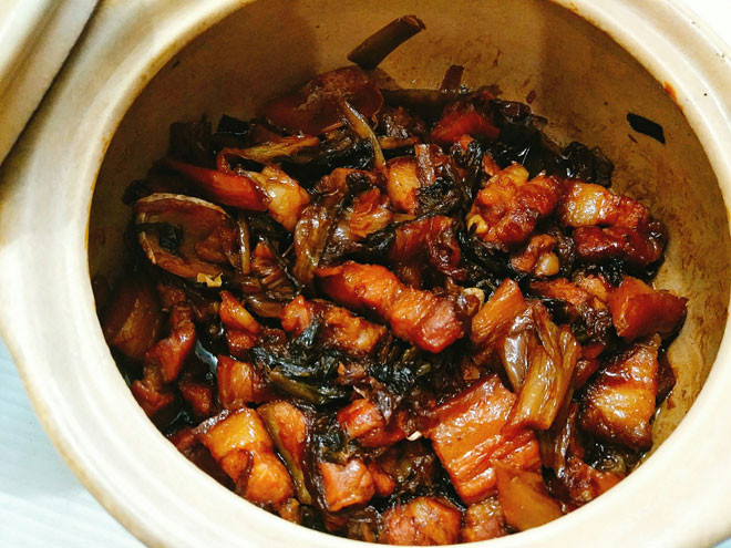 Bước 6: Cuối cùng bạn trút tất cả nguyên liệu sang nồi đất và thêm 1 chút nước xăm xắp mặt thịt, đậy nắp và kho lửa nhỏ liu riu cho tới khi thịt mềm, chuyển màu nâu đậm, thịt ngấm đều gia vị và rút cạn bớt nước là tắt bếp. Múc thịt kho dưa muối mặn ra tô để thưởng thức với cơm nóng thì ngon miễn chê.