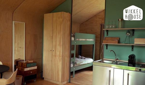 Bước tiếp vào là khu vực bếp nhỏ xinh nhưng chẳng thiếu thứ gì với gam màu xanh lạ mắt, vật dụng làm bếp được đặt gọn gàng trên kệ treo tường. Không gian tuy nhỏ nhưng vẫn đủ chỗ đặt một bộ bàn ăn gỗ xinh xắn để cả nhà cùng nhau thưởng thức bữa ăn.