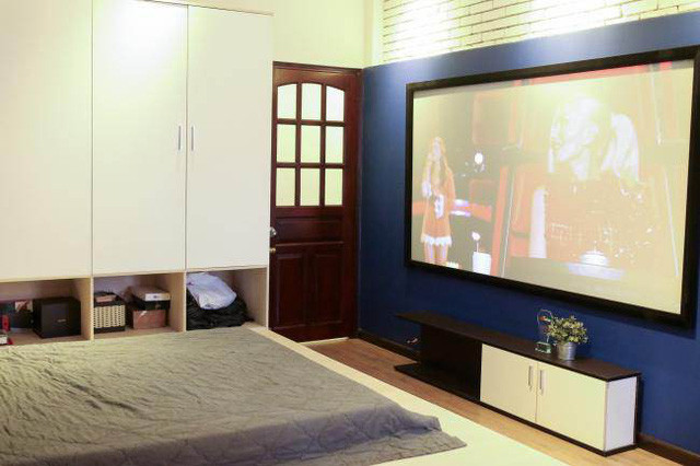 Anh sắm một chiếc tivi 100 inch đặt tại phòng ngủ để giải trí.