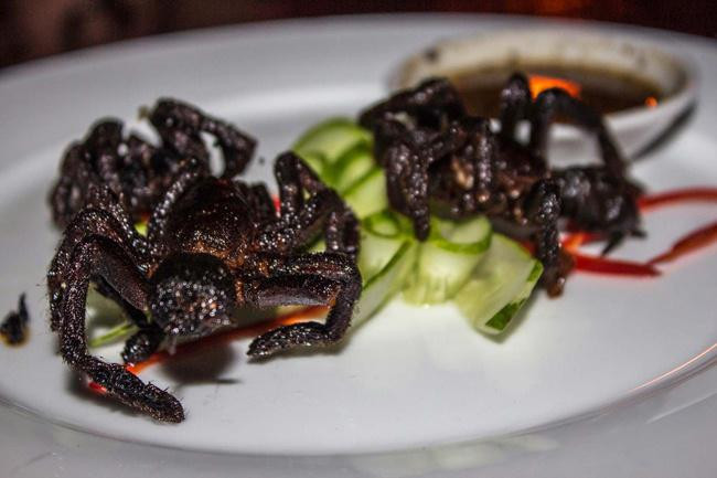 9. Nhện tarantula Món nhện đen rán giòn là đặc sản ở Campuchia. Nhện được làm sạch, ngâm sữa và sau đó rán giòn. Nhiều con to bằng bàn tay người và được cho là có vị ngon, bùi.