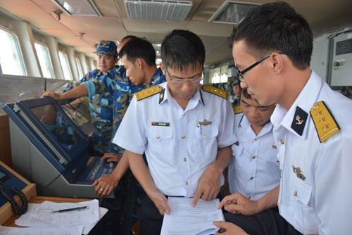 Bên cạnh việc cơ động theo đội hình, các tàu kết hợp diễn tập mã hóa và giải mã điện, thông tin liên lạc bằng cờ hiệu, ảnh đèn theo Bộ quy tắc ứng xử các tình huống gặp nhau bất ngờ trên biển (CUES), và chụp ảnh đội hình từ trên không. Theo nội dung tập luyện, tàu chỉ huy sẽ cung cấp các mã điện các tàu trong đội hình để giải mã và trả lời trong thời gian nhanh nhất. Hoạt động này giúp nâng cao hiểu biết chung giữa hải quân các nước. Trong ảnh: Thượng tá Đỗ Văn Triều, Trợ lý Phòng Thông tin, Quân chủng Hải quân (bên trái), đang trao đổi với nhóm sĩ quan tham gia diễn tập chia sẻ thông tin.