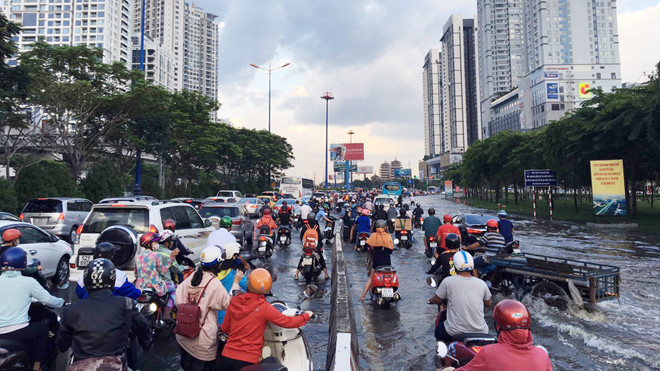 Nước tràn vào đường khiến việc đi lại khó khăn, giao thông di chuyển trên tuyến đường này cũng bị ùn ứ, một số đoạn trên đường Song Hành nước ngập lút nửa bánh xe máy. (Ảnh: Zing)