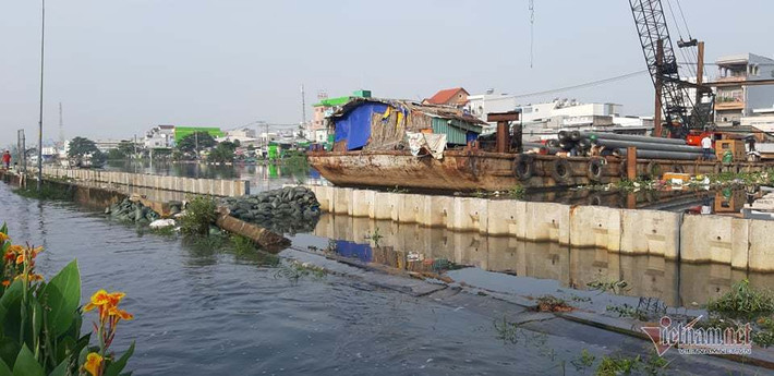 Triều cường dâng cao khiến một đoạn bờ bao dài 30m tại khu vực cầu Kênh Ngang số 3, thuộc đường Mễ Cốc, quận 8 (TP HCM) bị vỡ toang khiến hàng trăm nhà dân ngập nặng. (Ảnh: Vietnamnet)