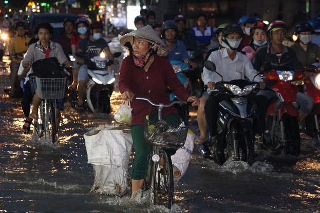 Người dân TP HCM vật vã với triều cường vào chiều tối tại đường Nguyễn Thị Thập, quận 7. (Ảnh: Baodautu)