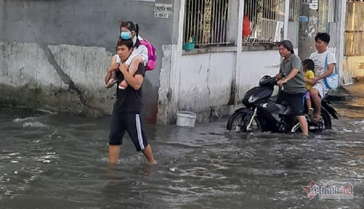 Nhiều phụ huynh phải lội qua dòng nước cõng con đi học. (Ảnh: Vietnamnet)