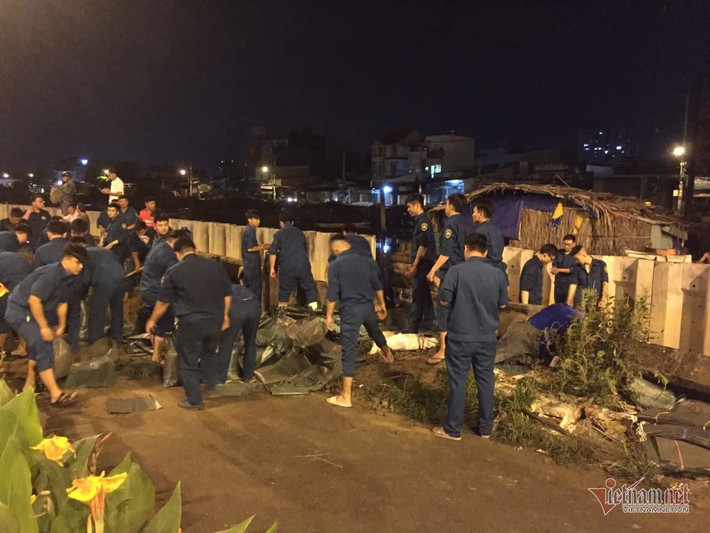 Triều cường dâng cao gây áp lực lớn khiến đoạn bờ kè gần khu vực cầu Kênh Ngang số 3 bị vỡ. Lực lượng chức năng quận 8 phải huy động hơn 150 dân quân, vận chuyển gần 10 ngàn bao cát để be bờ khắc phục sự cố. Đồng thời, hỗ trợ các hộ dân xây tạm các vách tường gạch ngăn nước vào nhà, sớm ổn định lại cuộc sống. (Ảnh: Vietnamnet)
