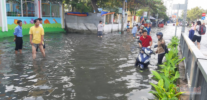 Do triều cường lên cao khiến cả trăm người dân vật vã khi di chuyển đến nơi làm việc, đưa con nhỏ đi học. (Ảnh: Vietnamnet)