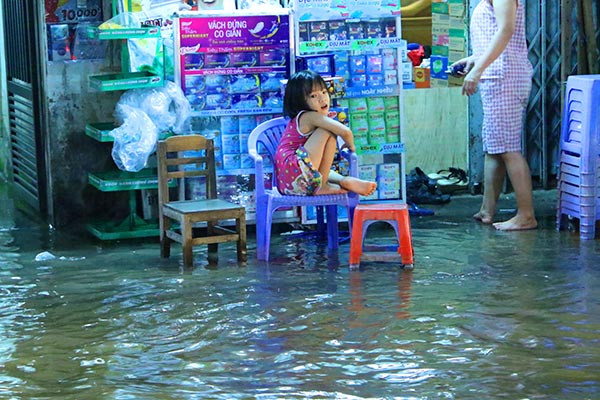 Tại khu Bình Quới, quận Bình Thạnh nhiều hộ dân phải kê ghế ngồi vì đường ngập đầy nước. (Ảnh: Baodautu)