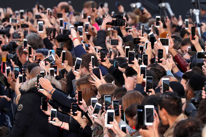 Người hâm mộ sử dụng điện thoại smartphone để ghi lại show trình diễn thời trang L'Oreal diễn ra tại Tuần lễ thời trang Pháp. Ảnh: Theatlantic.
