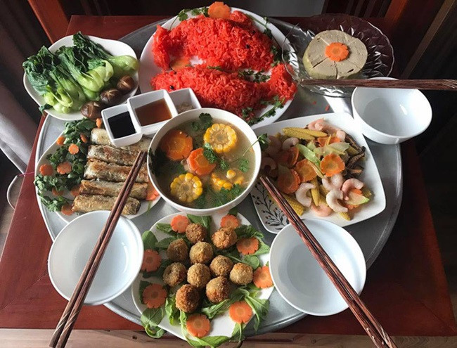 Mâm cơm cúng có đầy đủ món canh, món xào. Đặc biệt có đĩa xôi hình cá chép đỏ rực được nấu từ gạo nếp nương và gấc quê. Ảnh: FB Trang Ỉn
