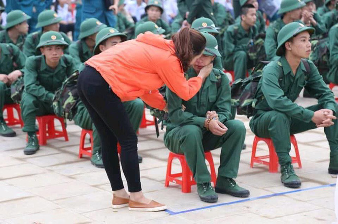 Hình ảnh mẹ ôm con, bạn gái ôm bạn trai, bố nắm tay con qua cửa kính xe khiến buổi giao nhận quân thêm phần bịn rịn.