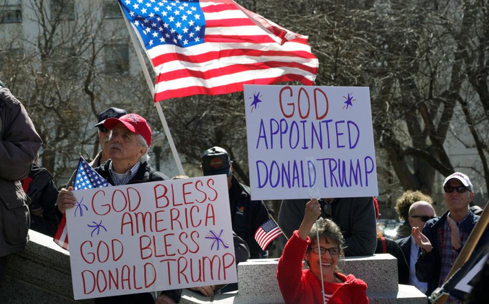 Những người tham gia cuộc diễu hành giăng cao cờ, biểu ngữ thể hiện sự ủng hộ với ông Trump. Ảnh Reuters