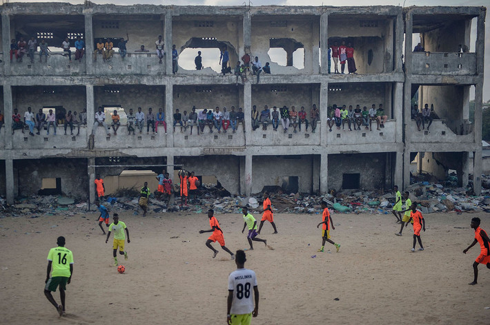 Người dân Somali đá bóng trong một ngôi trường học bị bỏ hoang sau khi nó bị bom đạn tàn phá ở Mogadishu, Somalia. Chiến tranh có thể tàn phá mọi thứ nhưng không thể ngăn được người dân Somali tìm đến môn thể thao vua. Nguồn ảnh: TA.