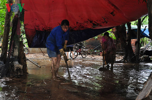 Bà Nguyễn Thị Thu bị dầu theo nước lũ tràn vào nhà than phiền: “Nước lũ mạnh quá, vừa nước lũ vừa dầu bây giờ nó bê bết”. Nguồn ảnh:VOV.