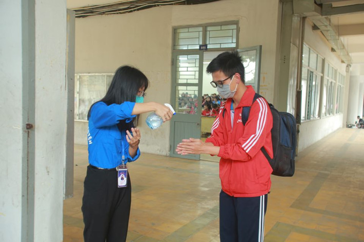 Xịt nước sát trùng tay, kiểm tra thân nhiệt là những việc làm bắt buộc của sinh viên trước khi vào giảng đường.