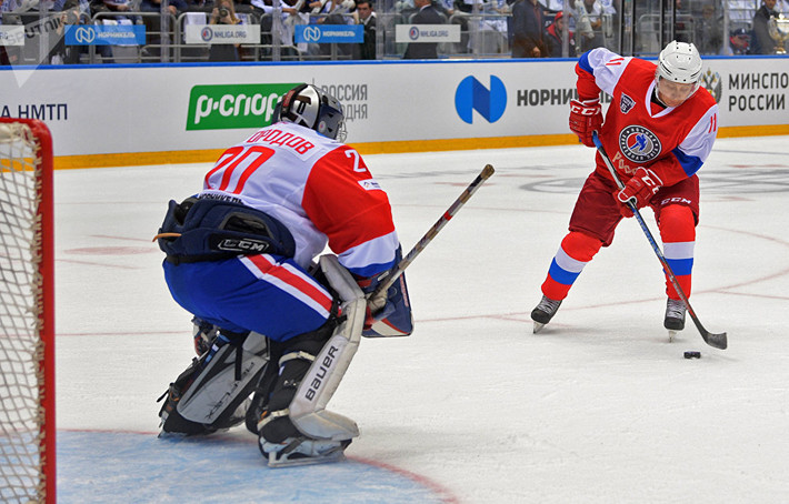 Ông Putin đang trổ tài chơi hockey trên băng trong một pha chạm trán với đội bạn.