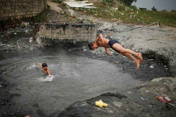 Các em bé háo hức bơi lội tại một bể nước nóng ở nơi đây. Ảnh Reuters