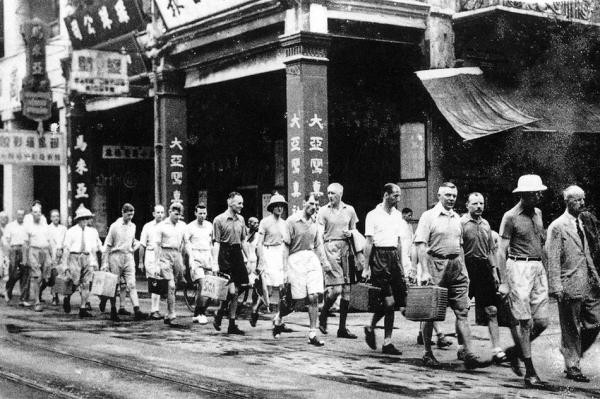 Thời quân Nhật chiếm đóng, rất nhiều tên đường, phố của Hồng Kông được đổi tên mang đậm bản sắc văn hóa Nhật Bản. Ví dụ “Queen's Road” được đổi thành “ Minh Trị”. Trong ảnh quân nhật đang bắt nhân viên nước ngoài của ngân hàng HSBC rời khỏi Hồng Kông.