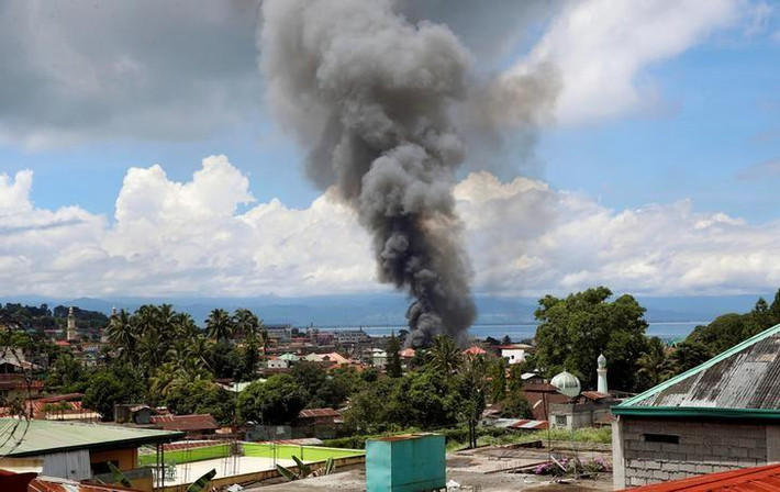 Hãng thông tấn Reuters ngày 27/5 đưa tin, lần đầu tiên các trực thăng Philippines nã tên lửa dẫn đường vào loạt vị trí của nhóm phiến quân ở nam Philippines nhằm chấm dứt sự chiếm đóng và giành lại quyền kiểm soát thành phố Marawi trên đảo Mindanao. Trong ảnh chụp ngày 27/5, khói bốc lên từ những ngôi nhà đang cháy ở Marawi trong cuộc giao tranh giữa lính chính phủ Philippines và nhóm Maute.