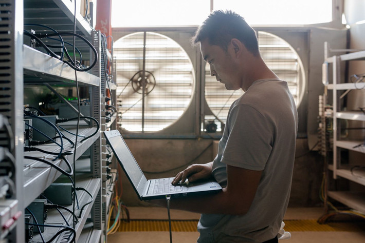Một "thợ mỏ" theo dõi quá trình vận hành của dàn máy đào Bitcoin.